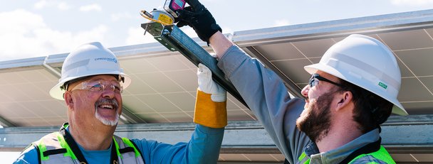Two Cypress Creek employees work at a solar facility