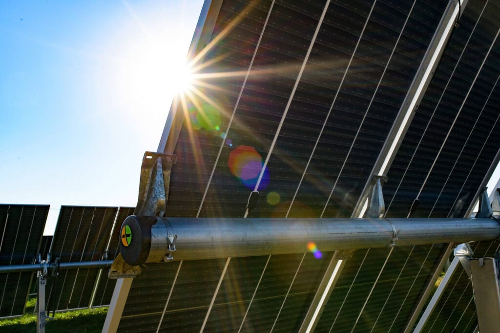 A rainbow and sun ray effect is created as the sun shines on a solar panel.